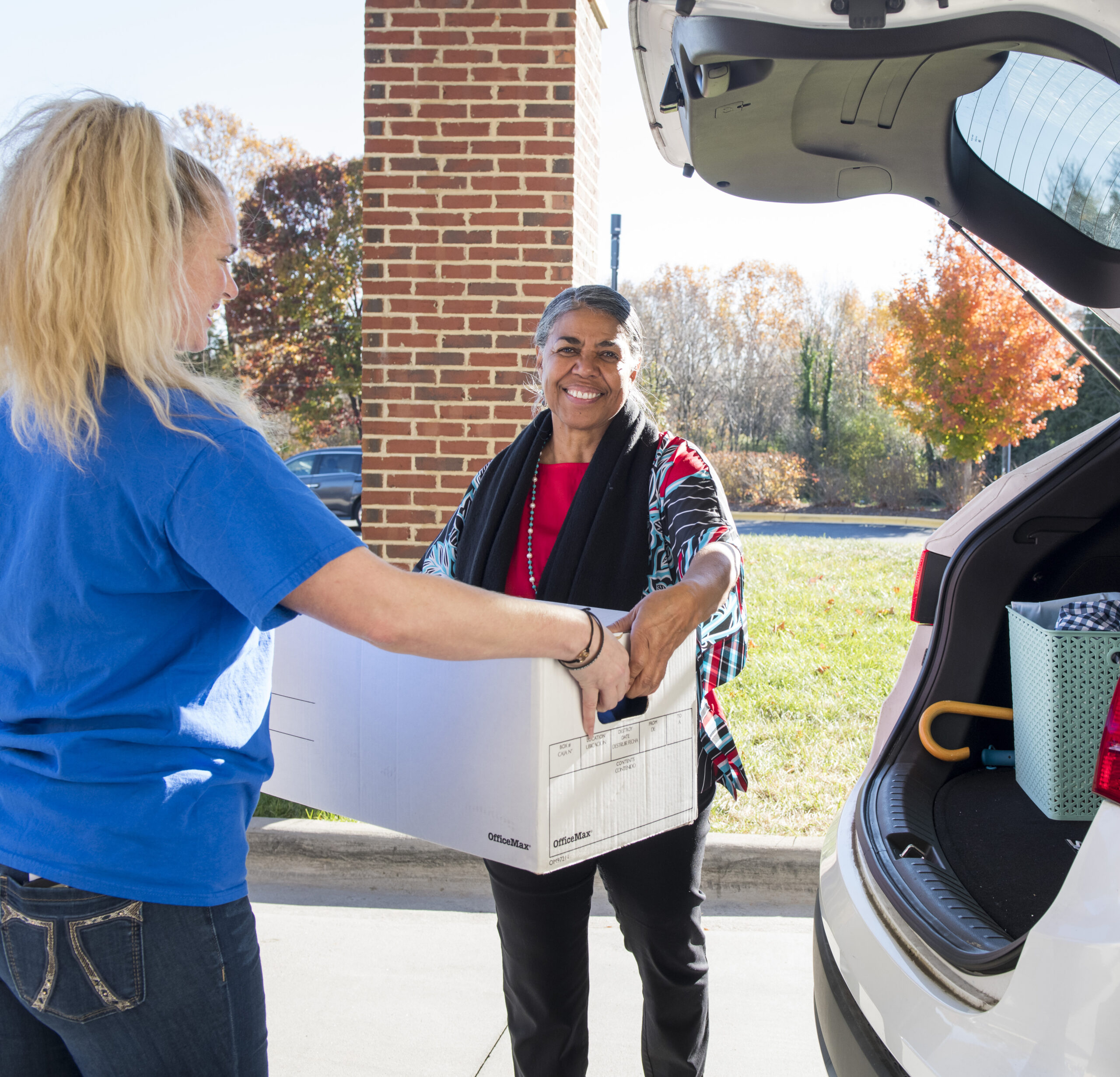 photo of two women helping with donation drop off of goods