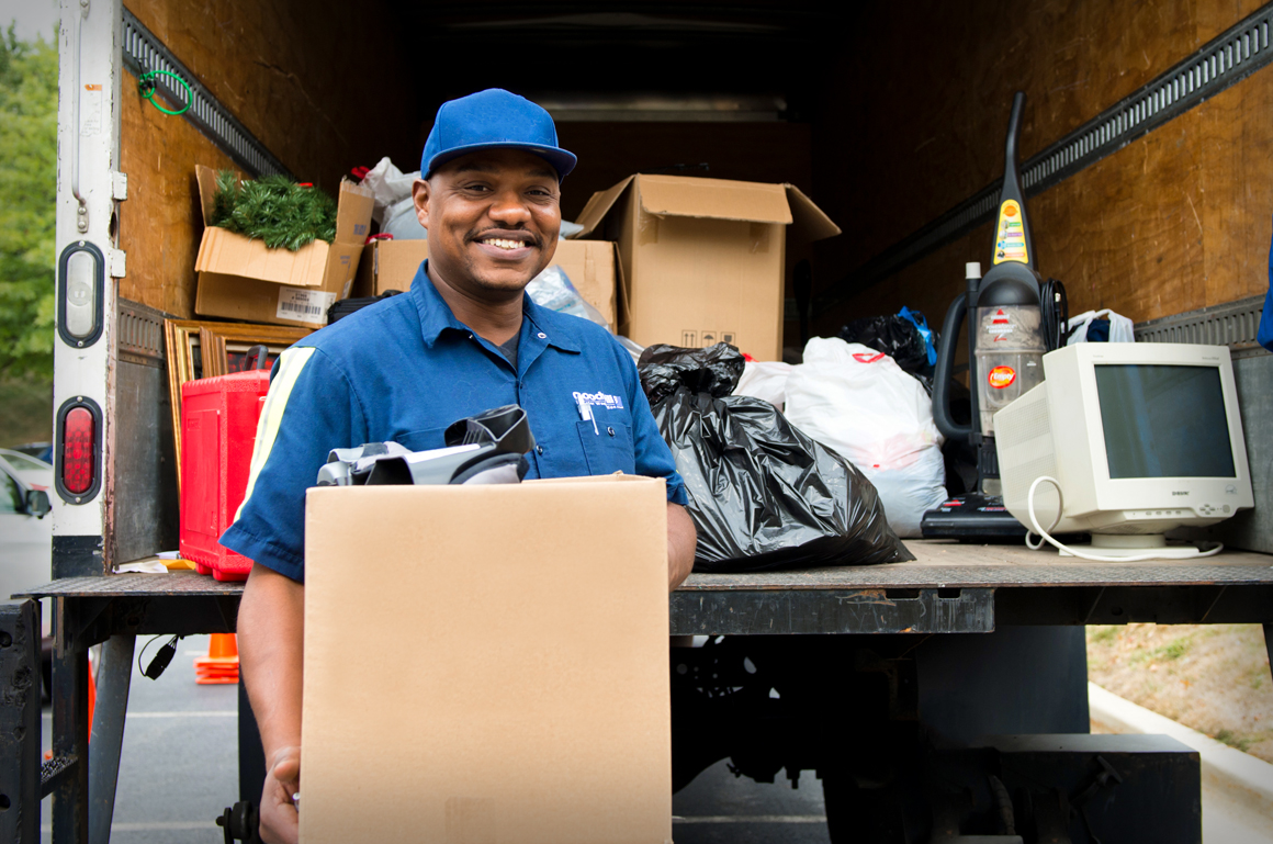 Smiling Goodwill worker in front of Donation Truck